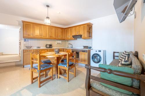 a kitchen with a wooden table and a dining room at Arte Lindos Suites in Líndos
