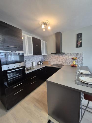 a kitchen with black cabinets and a counter top at D&D Studio Apartment in Velika Gorica