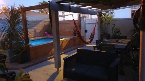 un patio avec un hamac et une piscine dans l'établissement Piscine, 3 chbs, terrasse, vue mer, à Palavas-les-Flots