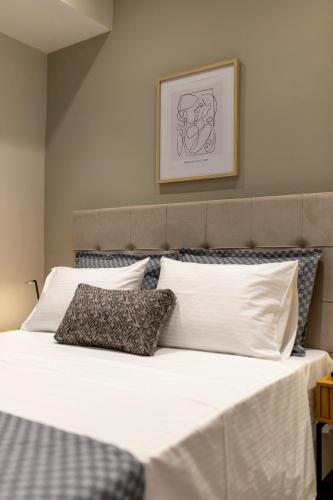 a bed with white sheets and pillows in a bedroom at Zerynthos Apartments in Therma