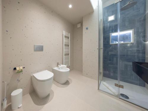 a bathroom with a toilet and a glass shower at Domus Eterea in Marsala