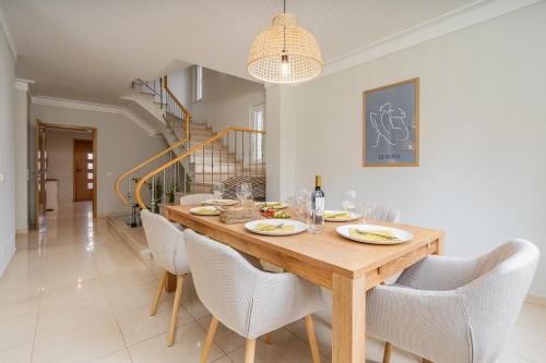 a dining room with a wooden table and chairs at Host Wise - Deluxe Spacious House with Terrace & Jacuzzi in Portimão