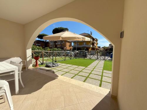 a view of a patio with an umbrella and a yard at Borgo Del Navigatore in Marina di Grosseto