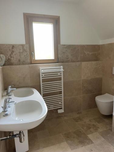 une salle de bain avec un lavabo et des toilettes dans l'établissement Le Val de Rance, à Saint-Samson-sur-Rance