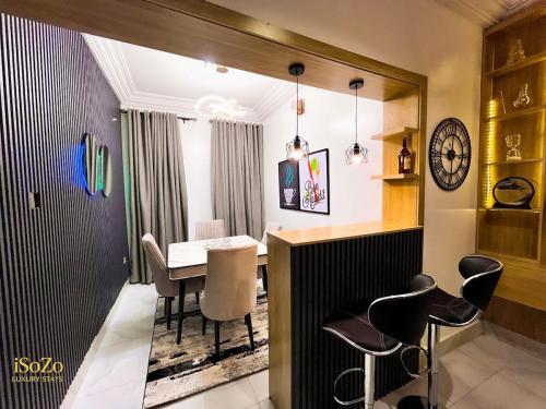 Un comedor con mesa y sillas en iSoZo Luxury Stays Apartment 2, en Ikeja