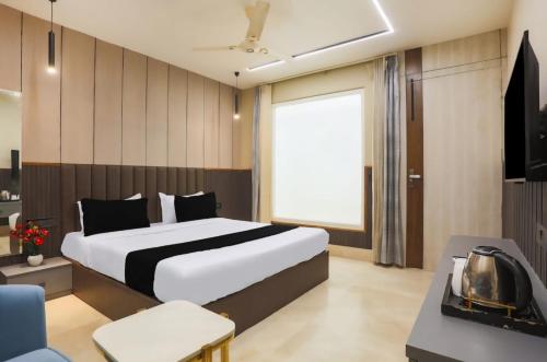 a bedroom with a large white bed and a television at Hotel heritage plaza in Hisār