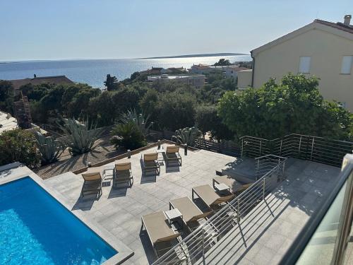 a view of a pool and chairs and the ocean at Villa INAMI in Mandre