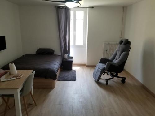 une chambre avec un lit, un bureau et une chaise dans l'établissement STUDIO CURISTES LAMALOU LES BAINs, à Lamalou-les-Bains