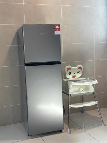 a refrigerator with a toy mouse on top of a stool at Theme Park Ipoh - Onsen Premier Suites By MICASA GROUP in Ipoh