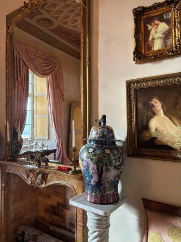 a vase on a stand in a room with a mirror at Castello di Casalborgone, Luxury Italian Castle Hotel in Casalborgone