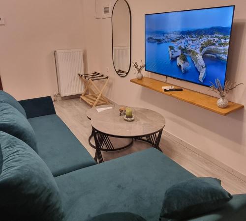 un soggiorno con un divano blu e una TV di Garden Oasis Residence a Stavros