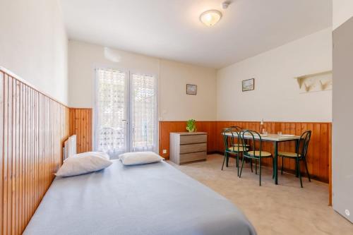 une chambre avec un lit, une table et des chaises dans l'établissement 24 - Le Paradisier - Village vacances, à Maché