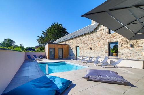 une piscine avec des chaises et un parasol dans l'établissement Luxueuse Longère 350m2 