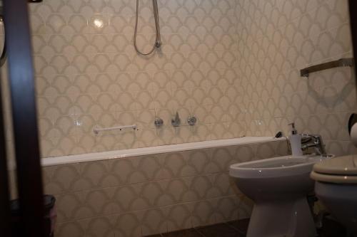 a bathroom with a tub and a toilet and a sink at Aurooms in Cinisi