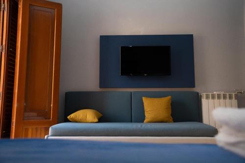 a blue couch with two yellow pillows in a room at Aurooms in Cinisi