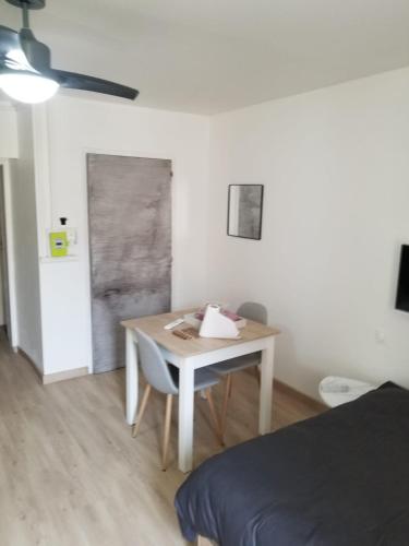 une pièce avec une table et un lit et une table et des chaises dans l'établissement STUDIO CURISTES LAMALOU LES BAINs, à Lamalou-les-Bains
