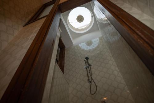 a bathroom with a shower with a round window at Aurooms in Cinisi