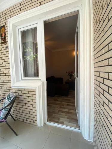 a door with a window in a brick wall at Guest House Deme in K'obulet'i