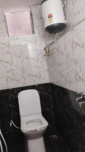 a bathroom with a white toilet and a sink at Misty Meadows Ooty in Ooty