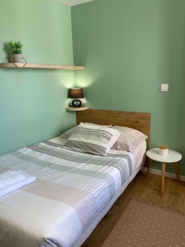 - une chambre avec un lit et une petite table dans l'établissement Chambres avec espaces communs équipés parfait pour séjour professionnel ou ambiance conviviale, à Laval