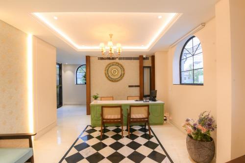 a lobby with a green island with chairs and a checkerboard floor at The Sunder Palace-Jaipur City Centre Hotel in Jaipur