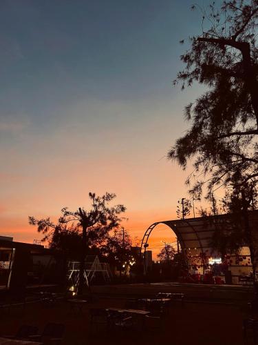 a sunset in a parking lot with trees and a building at DSD Resort in Háº£i Háº­u