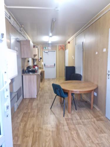 a room with a table and chairs and a kitchen at Hostel pracowniczy WOJTEK in Pogórze