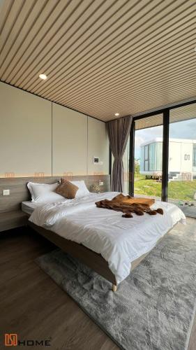 a bedroom with a large bed with a large window at DSD Resort in Háº£i Háº­u