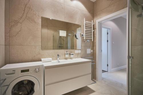 a bathroom with a washing machine and a sink at Baltic Park Plaza by Baltic Home in Świnoujście