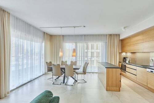 a kitchen and dining room with a table and chairs at Baltic Park Plaza by Baltic Home in Świnoujście