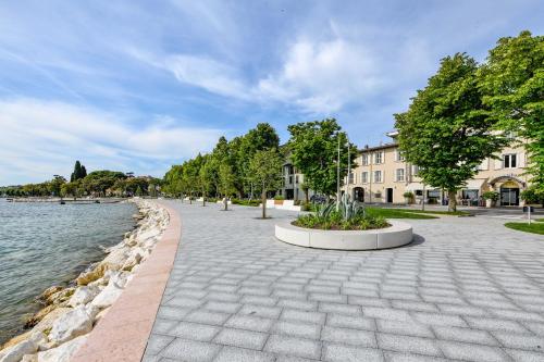 a brick walkway next to a body of water at Hotel Europa in Desenzano del Garda