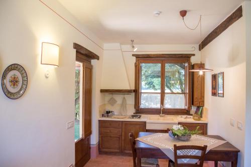 a kitchen with a table and a sink and a window at Vocabolo Monache in Ponte Pattoli