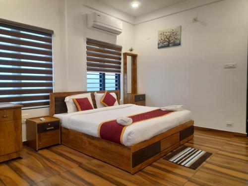 a bedroom with a bed and a window at VGK Residency in Wayanad