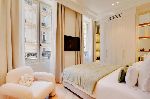 une chambre blanche avec un lit et une chaise dans l'établissement Maison Galante's apartments with Services in La Madeleine - Opéra, à Paris