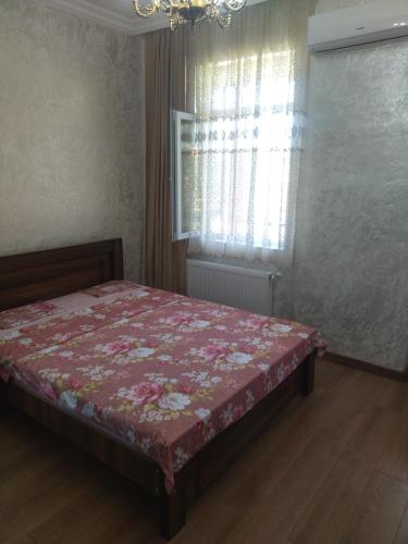 a bedroom with a bed with a floral bedspread on it at White House Avtandil&Nino in Sarpi