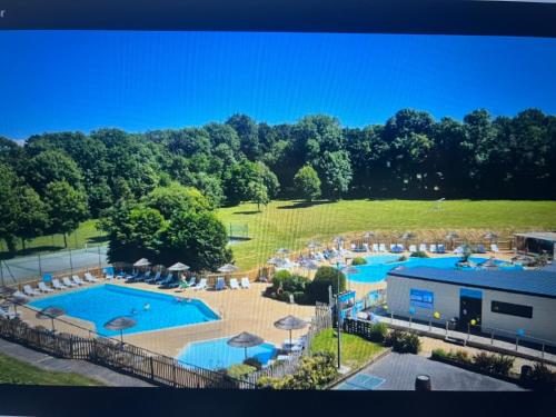 - une vue aérienne sur une grande piscine avec des parasols dans l'établissement Doeland 04, à Clohars-Carnoët