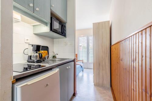 une cuisine avec un évier et un micro-ondes dans l'établissement 28 - La Pérruche - Village vacances, à Maché