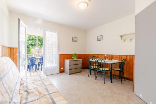 une chambre avec un lit, une table et des chaises dans l'établissement 28 - La Pérruche - Village vacances, à Maché
