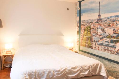 une chambre avec un lit blanc et une grande fenêtre dans l'établissement Cosy and practical studio in the heart of 15ᵉ, à Paris