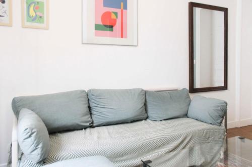 - un canapé dans le salon avec un miroir dans l'établissement Design apartment with WiFi in the heart of Paris, à Paris