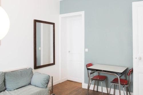 un salon avec un canapé, une table et un miroir dans l'établissement Design apartment with WiFi in the heart of Paris, à Paris