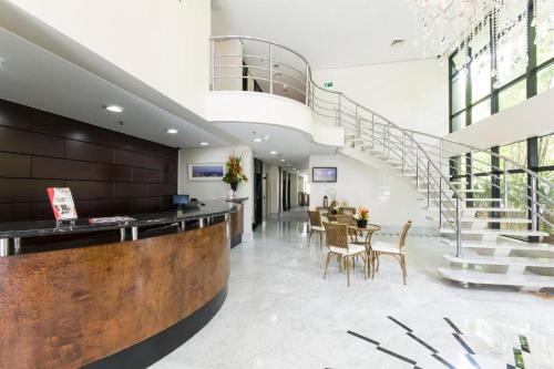 a lobby with a staircase and a table and chairs at The Palace Flat Moema in Sao Paulo