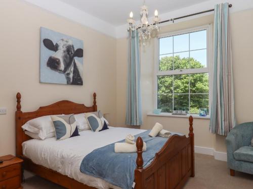 ビデフォードにあるLittleham Court Manorのベッドルーム1室(壁に牛の絵が描かれたベッド1台付)