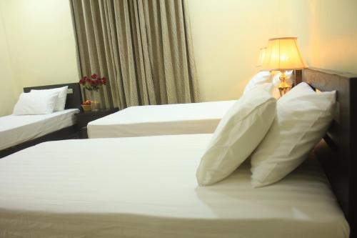 a hotel room with two beds with white pillows at Starlit Hotel - Gilgit in Gilgit