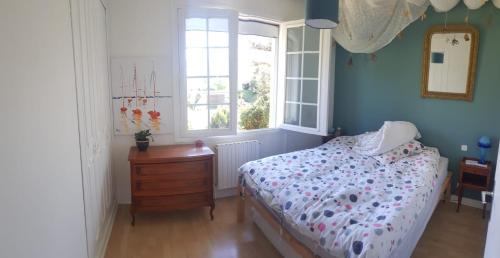 une chambre avec un lit, une commode et une fenêtre dans l'établissement Au petit Ruisseau, maison à Capbreton, à Capbreton