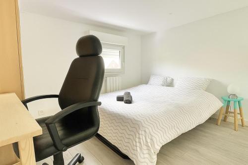 a bedroom with a bed and a chair in it at Maisonnette Villeneuve d Ascq in Villeneuve d'Ascq