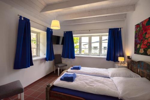 ハーフクルークにあるLandhaus-Marwede App7の青いカーテン付きのベッドルームのベッド2台