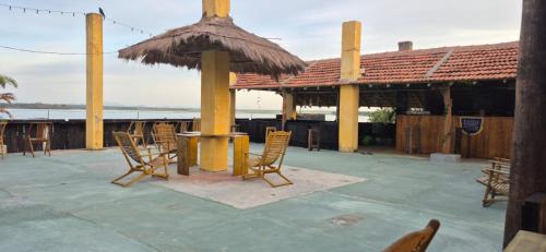 a patio with chairs and a table and an umbrella at Rise & Set Arugam bay in Arugam Bay