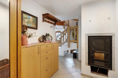 a kitchen with a wooden dresser and a fireplace at Almschlössle in Gottmadingen