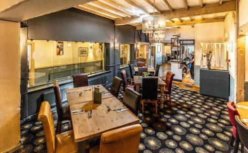 SudburyにあるThe Boars Head Hotelの部屋に木製のテーブルと椅子が置かれたレストラン